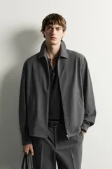 Sobrecamisa regular fit color gris, con cuello solapa, manga larga con puño abotonado, bolsillos de vivo en la cadera y cierre frontal con cremallera de doble dirección.