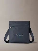 Bandolera Calvin Klein Jeans color azul marino, de forma rectangular con logo estampado en el frente, bolsillo externo con cierre y correa de hombro ajustable.