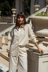 Conjunto de dos piezas compuesto por camisa de manga larga con botones frontales y pantalón de corte recto, ambos en color negro con estampado de pequeños puntos brillantes tipo strass.