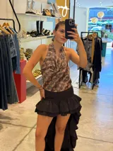 Falda de satén marrón con diseño de doble volado en la parte delantera y largo irregular, con forro de short incorporado por debajo y cierre invisible en el costado.