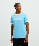 Remera de algodón color celeste con cuello redondo y bordes de mangas en color blanco. Presenta la palabra 'ARGENTINA' estampada en el pecho con tipografía blanca.