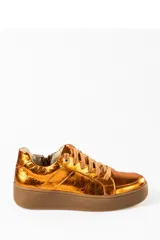 Zapatillas deportivas color naranja metalizado con cordones marrones y suela marrón.