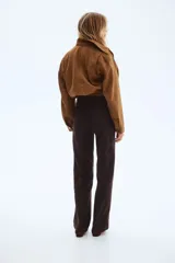 Pantalón jean de tiro alto en color marrón, de corte amplio y relajado, con bolsillos delanteros de parche y raya marcada al frente.