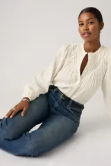 Jeans de corte recto y tiro alto, con diseño clásico de cinco bolsillos y acabado en tono azul medio con ligero desgaste.