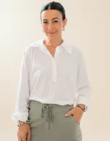 Chomba de algodón blanca con cuello camisero y cierre frontal parcial, de manga larga y calce holgado.