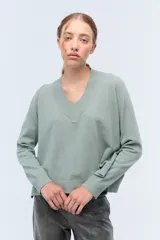 Sweater de tejido de punto color verde agua, con escote en V y calce holgado.