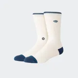Medias de caña media Stance, color blanco con puntera y talón en contraste azul marino. Presentan el logo de la marca bordado en la parte superior y un pequeño detalle gráfico en el lateral.