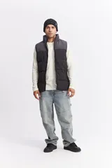 Chaleco puffer bicolor con diseño en bloques, cierre frontal y bolsillos funcionales. Presenta un ajuste regular y logo de la marca estampado en el pecho.