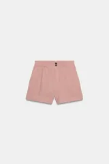 Bermuda de tiro alto de lino color rosado, con cintura elástica trasera, bolsillos delanteros, bajo con vuelta y cierre frontal con cremallera y botones.