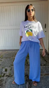 Pantalón de corte ancho y relajado, confeccionado en lino con diseño de rayas verticales. Presenta cintura elástica con cordón de ajuste y bolsillos laterales.