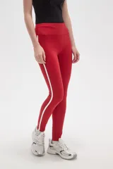 Calza deportiva de tiro alto, color rojo, confeccionada en poliamida con ajuste al cuerpo.