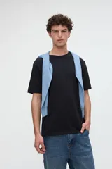 Remera de manga corta básica color negro, confeccionada en jersey de algodón de textura suave, con cuello redondo y calce clásico.