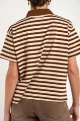 Remera polo de manga corta con diseño a rayas horizontales en tonos marrones, beige y negros, cuello en contraste y cierre frontal de botones.