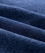 Campera estilo bomber marca Blue Steel confeccionada en jean de algodón con lavado azul. Presenta diseño boxy estructurado, cuello camisero, cierre frontal, bolsillos laterales y elásticos en los puños y en el ruedo.