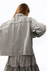 Campera corta en denim de algodón con cuello, cierre frontal de botones y bolsillos de parche delanteros.