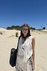 Top sin mangas color crudo con rayas verticales en tono beige y estampado abstracto en tonos tierra y negro.