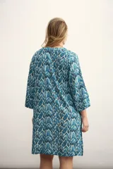 Vestido corto con estampado abstracto en tonos azules y blancos, escote en V con lazo ajustable y mangas 3/4 acampanadas.