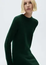 Vestido corto de punto en color verde oscuro, con cuello redondo y manga larga. Presenta un diseño recto y tejido de punto medio.