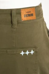 Jean de tiro bajo con fitting baggy y diseño tipo barrel, de color verde militar, con bolsillos delanteros y traseros y cierre de botón y cremallera.