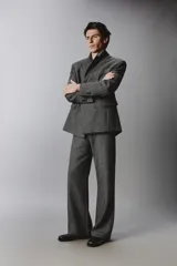 Pantalón de traje relaxed fit en color gris oscuro con diseño de espiga. Cuenta con bolsillos frontales, bolsillos traseros de vivo y cierre frontal con cremallera y botón.