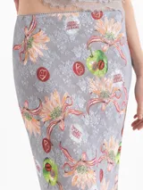 Pollera midi gris con estampado floral y detalles artísticos, de corte tubo y tiro medio, con terminación de encaje en el ruedo.