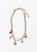 Pulsera doble dorada de acero quirúrgico con dijes de corazones y strass.