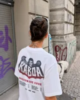 Remera blanca de manga corta, corte regular y cuello redondo, con gran estampado en la espalda de temática "Worldwide Tour" con una calavera y texto en rojo, azul y blanco.