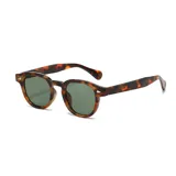 Lentes de sol redondos con montura de carey y lentes verdes.