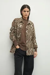 Polera color beige de manga larga con puños elastizados y aberturas laterales.