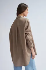 Camisa oversize color visón, de manga larga y corte holgado.