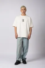 Remera color crudo, corte oversize, mangas cortas y cuello redondo. Estampado frontal con dos árboles unidos por sus raíces y parche estampado en la espalda con una silueta de mano que se fusiona con ramas.