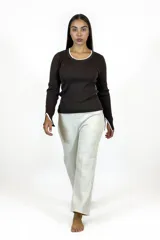 Buzo de punto acanalado en color marrón chocolate, con cuello redondo y puños con aberturas laterales. Presenta detalles de ribete en color blanco en el cuello, el ruedo y los puños.