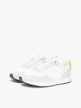 Zapatillas de estilo runner de Tommy Hilfiger, confeccionadas en una mezcla de cuero y textil en color blanco con detalles en gris claro y un panel amarillo en el talón. Presentan cordones blancos y suela de goma con base oscura.
