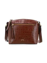 Cartera bandolera de cuero con textura efecto cocodrilo en color marrón chocolate. Cuenta con un compartimento principal con cierre, un bolsillo frontal externo con cierre y tiradores de cuero, herrajes metálicos dorados, logo metálico de la marca en el frente y correa ajustable para el hombro.