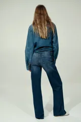 Jean wide leg de tiro alto en denim de algodón con ligero stretch, cinco bolsillos, lavado azul con efecto deslavado y terminación desmechada en el bajo.