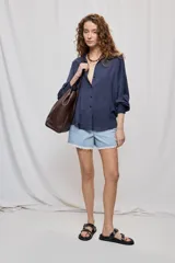 Short de denim de tiro medio y calce recto, con terminación desflecada en el ruedo y detalles florales bordados al tono en el frente.