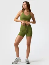 Top deportivo de soporte alto en color verde militar, con tirantes ajustables cruzados en la espalda y diseño con escote en V.