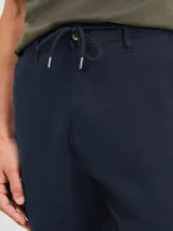 Bermuda color beige con cordón ajustable en la cintura.