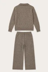 Conjunto de dos piezas compuesto por un sweater de punto trenzado con cuello polo y un pantalón de corte recto, ambos confeccionados en tejido de punto suave color marrón.
