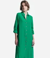 Vestido chemise largo color naranja, confeccionado en viscolino. Tiene cuello solapa, cierre con botones, manga larga con martingale, aberturas laterales y no tiene estampado.