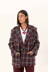 Blazer de corte oversize con estampado de cuadros en tonos azul, bordó y marrón. Presenta solapas clásicas, bolsillos con solapa en el frente y cierre frontal con botones.