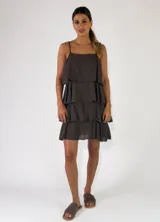 Vestido corto verde militar con diseño de solera con tirantes finos, escote recto y múltiples volantes horizontales escalonados.