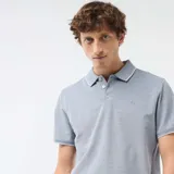 Chomba celeste melange de manga corta con cuello polo y ribetes blancos en el cuello y los puños. Presenta cierre frontal con tres botones y un pequeño logo bordado en el pecho.