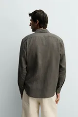 Camisa celeste de lino de corte regular fit, con cuello abotonado, manga larga y cierre frontal de botonadura.