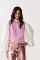 Top tejido de punto color rosa con lúrex, sin mangas y cuello a la base.