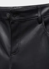 Pantalón largo de tiro medio en tejido efecto piel de color negro, con diseño recto, bolsillos y cierre frontal de cremallera y botón.