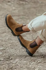 Botas de cuero marrón con elásticos laterales y suela negra.