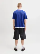 Camiseta de estilo polo con cuello camisero, manga corta y calce relajado. Presenta un diseño en color azul con estampado frontal "FIFA WORLD CUP" y detalles gráficos en contraste. Confeccionada en tejido técnico de poliéster reciclado.