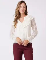 Blusa de encaje color beige, marca Cupio, con cuello a la base y escote en V con lazo de ajuste. Presenta una sobrecapa de encaje con aplique de puntilla y mangas largas de encaje floral translúcido, terminadas en puños elásticos con volado. Incluye forro interno a tono.