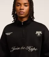 Buzo negro de algodón con felpa, corte boxy, cuello alto con cremallera, mangas largas con puños ajustados y bordado con la frase "Join the hype".